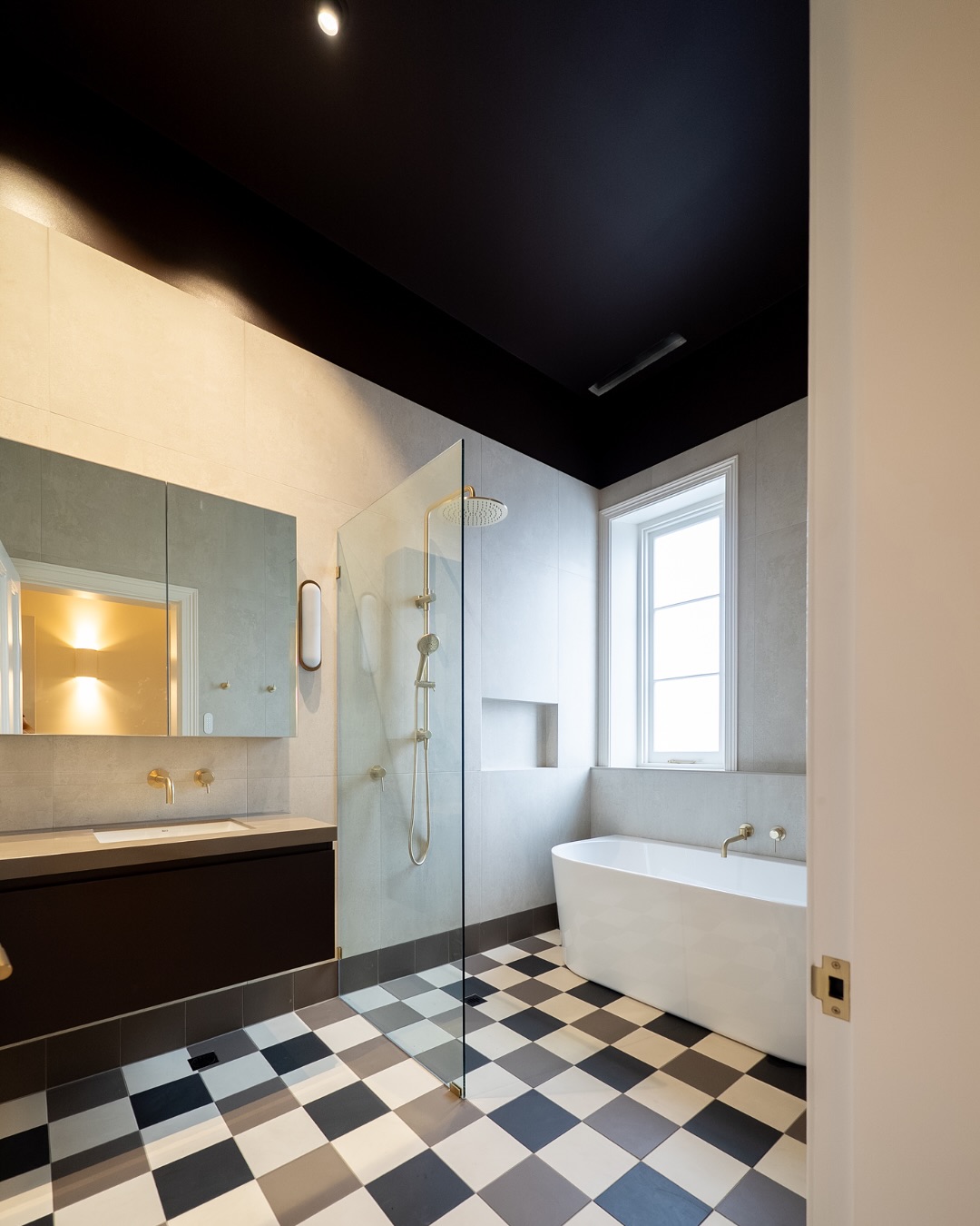 Wide view of Adelaide bathroom renovation with bath, shower, vanity and checkerboard tiles