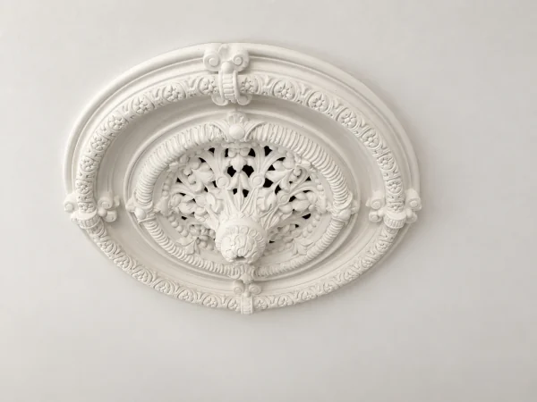 Finish visualisation of a classic circular plaster ceiling rose with four ornamental clasps and a leafy centre against a smooth painted ceiling