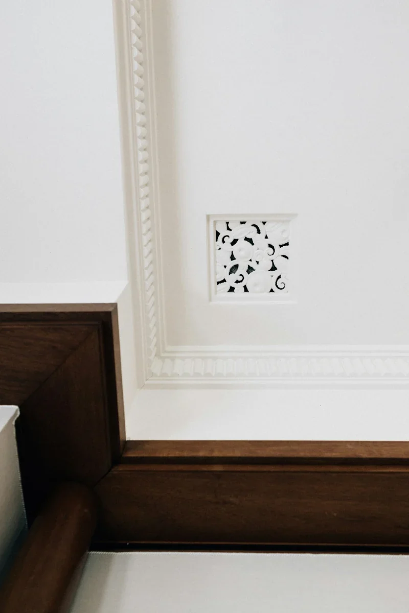 Reference photograph of a period cornice, timber trim and decorative wall vent