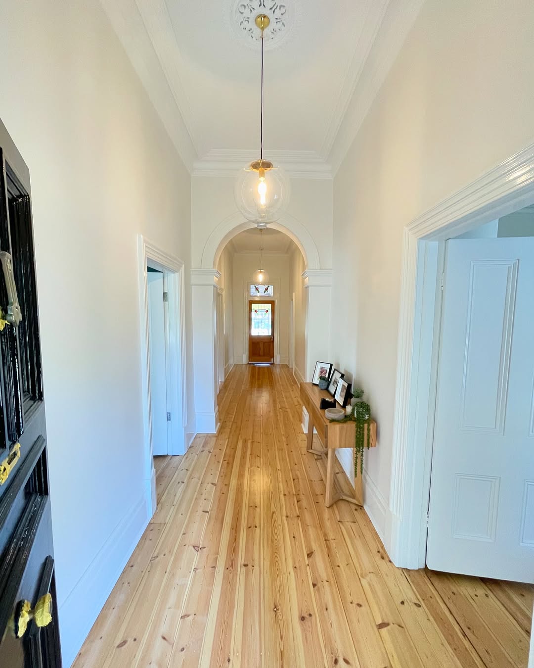 Restored Mitcham hallway with polished timber floor and arched opening