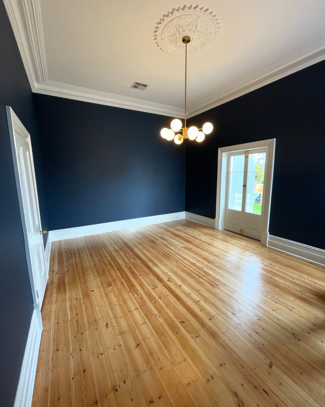 Restored Mitcham heritage room with dark walls, timber floor and ceiling rose