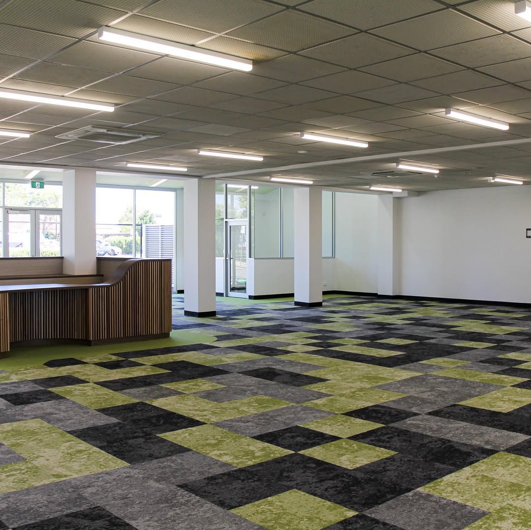 Open Mount Carmel College library area with timber slat counter and carpet tiles