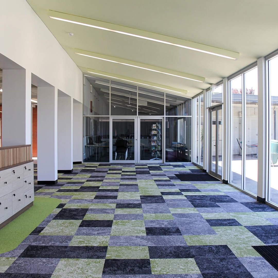 Library corridor area with glass partitions and green patterned carpet