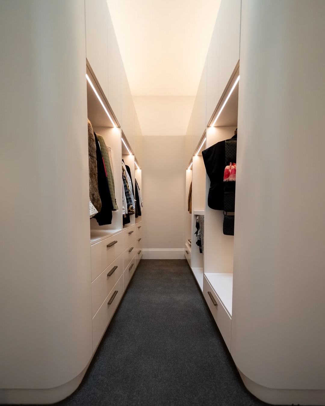 Long North Street walk in robe with rounded cabinetry, drawers and grey carpet
