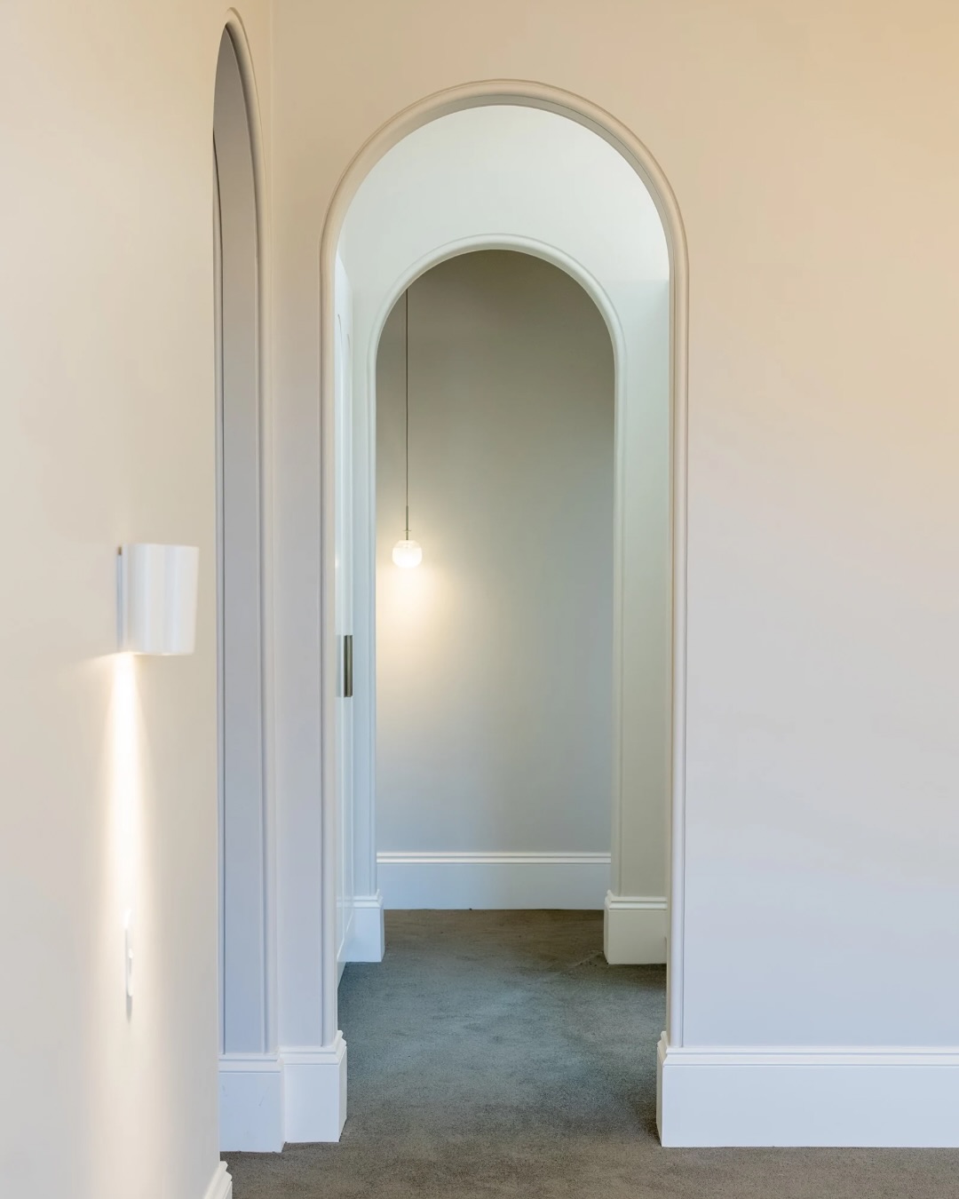 Arched entry to the North Street walk in robe with wall light and soft carpet